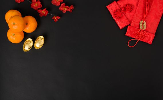 Chinese new year festival concept, flat lay top view, Happy Chinese new year with Red envelope and gold ingot (Character "FU" means fortune, blessing) on black background with copy space for text