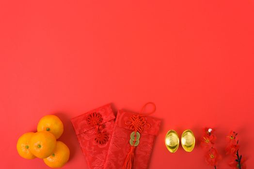 Chinese new year festival concept, flat lay top view, Happy Chinese new year with Red envelope and gold ingot (Character "FU" means fortune, blessing) on red background with copy space for text