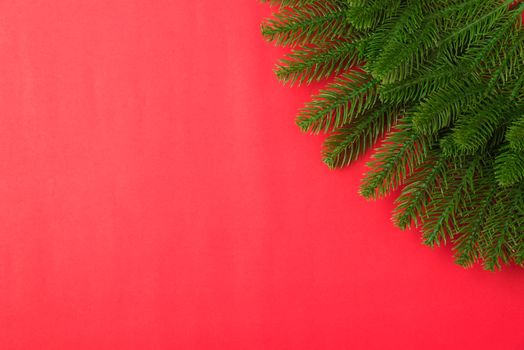 Happy new year or christmas day top view flat lay fir tree branches on red background with copy space for your text