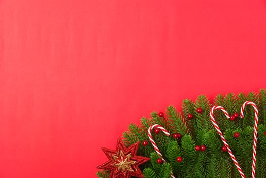 Happy new year or christmas day top view flat lay fir tree branches and ornaments decoration on red background with copy space for your text