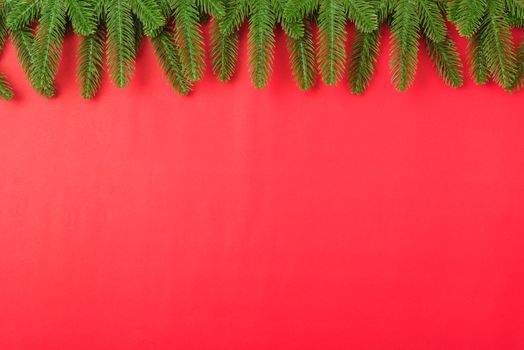Happy new year or christmas day top view flat lay fir tree branches on red background with copy space for your text