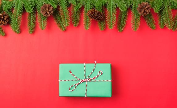 Happy new year or christmas day top view flat lay fir tree branches and gift box, decoration on red background with copy space for your text
