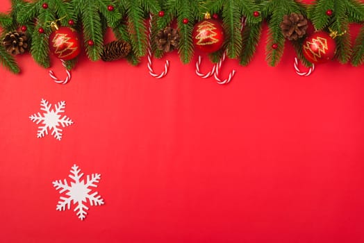 Happy new year or christmas day top view flat lay fir tree branches and decoration on red background with copy space for your text