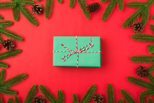 Happy new year or christmas day top view flat lay fir tree branches and gift box, decoration on red background with copy space for your text