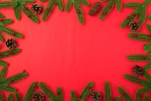 Happy new year or christmas day top view flat lay fir tree branches and decoration on red background with copy space for your text