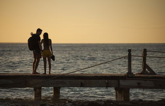 BAYAHIBE, DOMINICAN REPUBLIC 13 DECEMBER 2019: Young couple in love on the pier at susnset