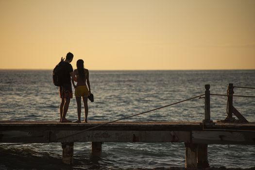 BAYAHIBE, DOMINICAN REPUBLIC 13 DECEMBER 2019: Young couple in love on the pier at susnset