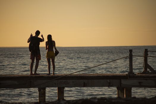 BAYAHIBE, DOMINICAN REPUBLIC 13 DECEMBER 2019: Young couple in love on the pier at susnset