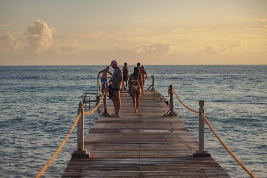 BAYAHIBE, DOMINICAN REPUBLIC 13 DECEMBER 2019: People on the pier at sunset