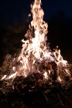 A low light underexposed photo of burning fire. Many sparks and flames. Burning books and wood. 