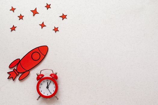 Red rocket border with alarm clock and stars over white with copy space in a conceptual image