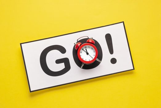 A go sign with an alarm clock as the O on a yellow background with copy space.