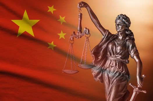 Figure of Justice with the national flag of China holding the scales and sword of law and order
