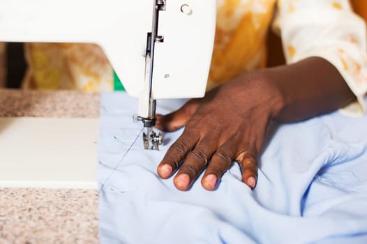 closeup of the woman's hand behind a sewing machine.