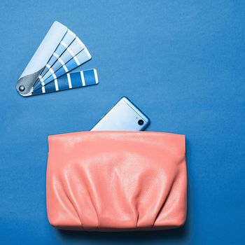 Pink coral female leather bag over classic blue 2020 color background. Color of year 2020 concept for fashion and clothing industry. Copy space for text or design
