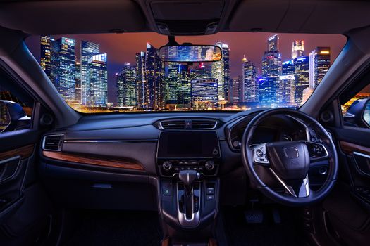 Looking through a car windshield with cityscape at night. Travel in car.