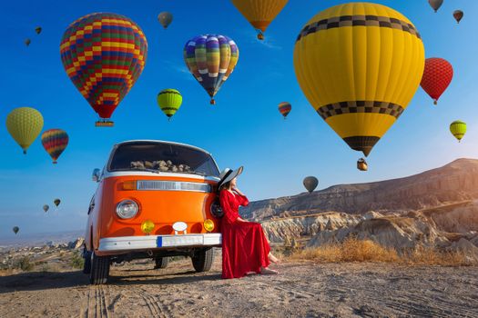 Beautiful girl looking at hot air balloons in Cappadocia, Turkey.