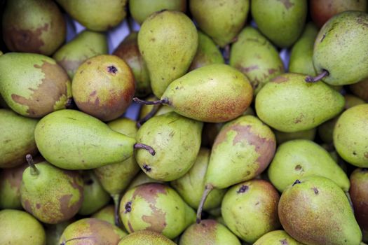 Seasonal fruits are placed in boxes in the grocery store. Close-up of fresh pears. Natural foods rich in vitamins for a healthy diet.