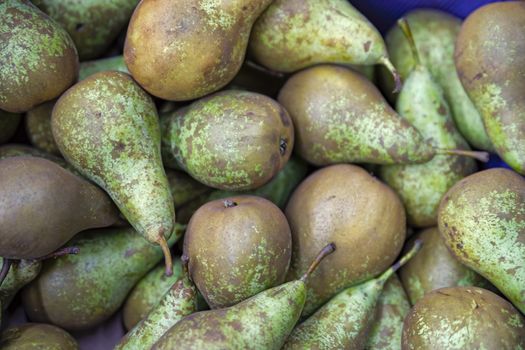 Seasonal fruits are placed in boxes in the grocery store. Close-up of fresh pears. Natural foods rich in vitamins for a healthy diet.