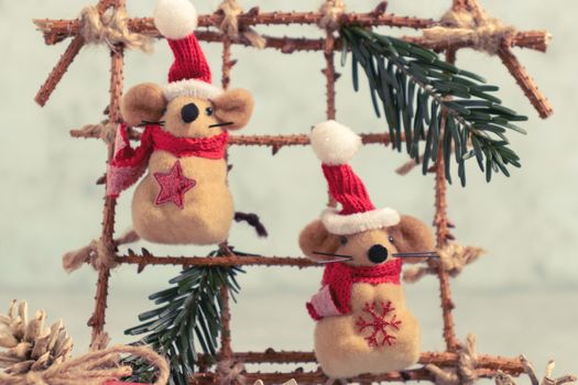 Two Little toy Christmas mice and decorations from natural materials on table. Christmas composition with symbol of 2020 according Chinese horoscope.