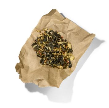 Green tea with aromatic additives. Top view on white background.