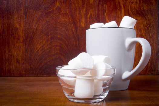 Cup with cocoa and marshmallows on a wooden table