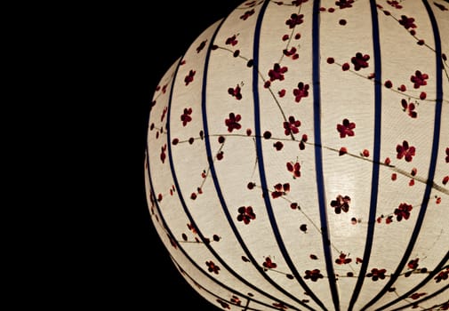 Close-up of white Chinese lantern over black background