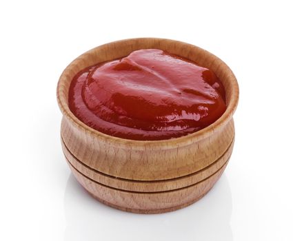 Ketchup in wooden bowl isolated on white background