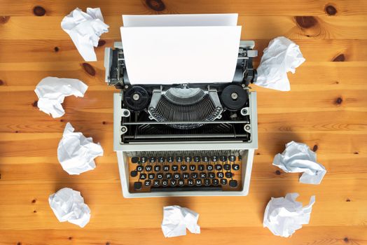 Writer's block. Typewriter and crumpled paper on work desk. Creative process concept