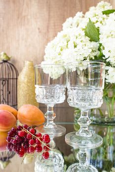 Rose wine in glasses. Rose wine on golden bottles background with flowers and fruits