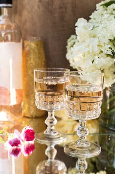 Rose blush wine in glasses. Bottle of rose wine with flowers on background. Prosecco.