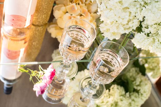 Rose blush wine in glasses. Bottle of rose wine with flowers on background. Prosecco.