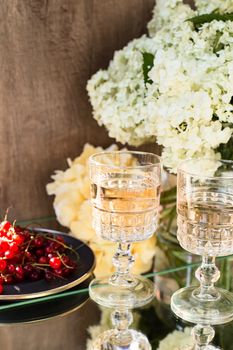 Rose wine in glasses. Rose wine on golden bottles background with flowers and fruits