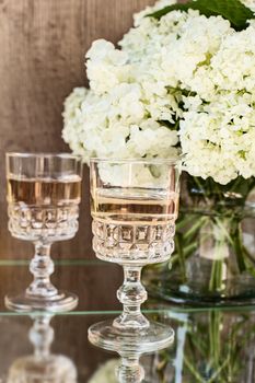 Rose blush wine in glasses. Bottle of rose wine with flowers on background. Prosecco.