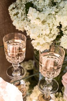 Rose blush wine in glasses. Bottle of rose wine with flowers on background. Prosecco.