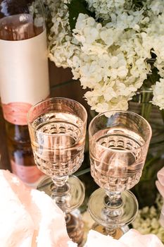 Rose blush wine in glasses. Bottle of rose wine with flowers on background. Prosecco.