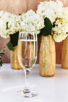 Rose wine in glasses. Rose wine on golden bottles background with flowers
