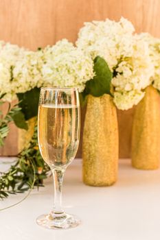 Rose wine in glasses. Rose wine on golden bottles background with flowers