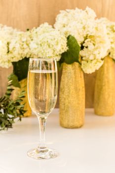 Rose wine in glasses. Rose wine on golden bottles background with flowers