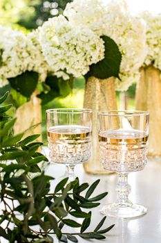 Rose wine in glasses. Rose wine on golden bottles background with flowers