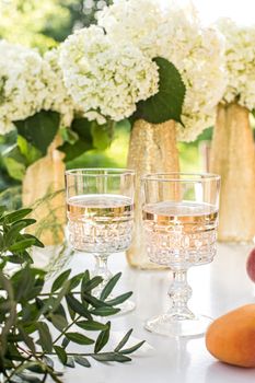 Rose wine in glasses. Rose wine on golden bottles background with flowers