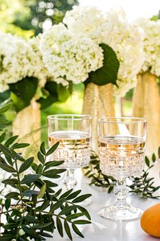 Rose wine in glasses. Rose wine on golden bottles background with flowers