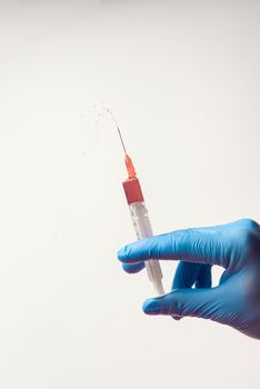 Hand in glove with syringe on white background. Injections.