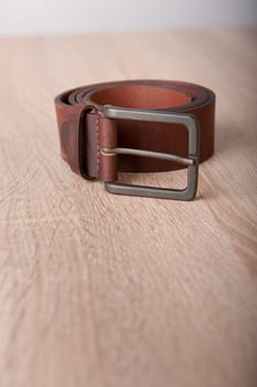 Leather belt on the wooden desk table