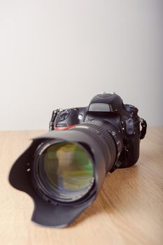 Digital photo camera on wooden desk table