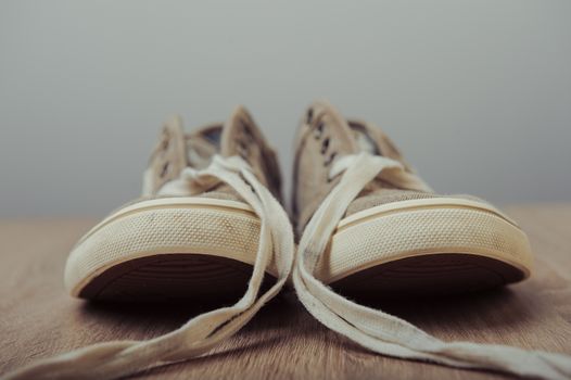 Blue lovely used sneakers on wooden desk