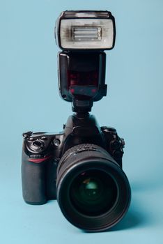 Professional modern DSLR camera against blue background
