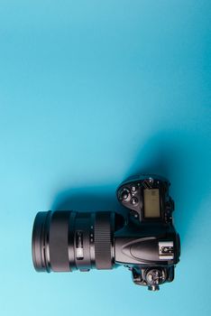 Professional modern DSLR camera against blue background