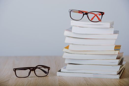 book and eyeglasses on wood background desk