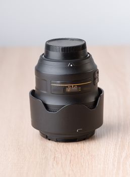 Closeup of a photographic lens on wooden table